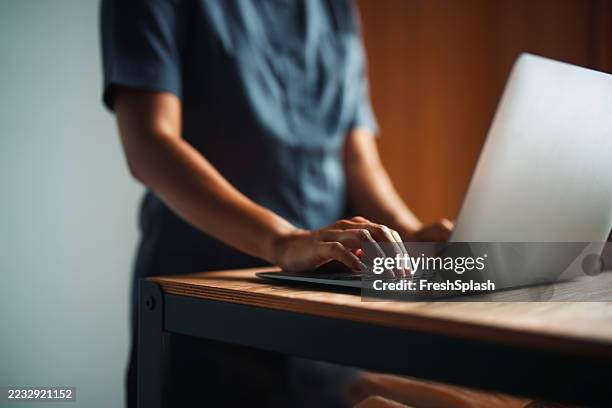 hands typing on a laptop at workstation in comfortable light - typing stock pictures, royalty-free photos & images