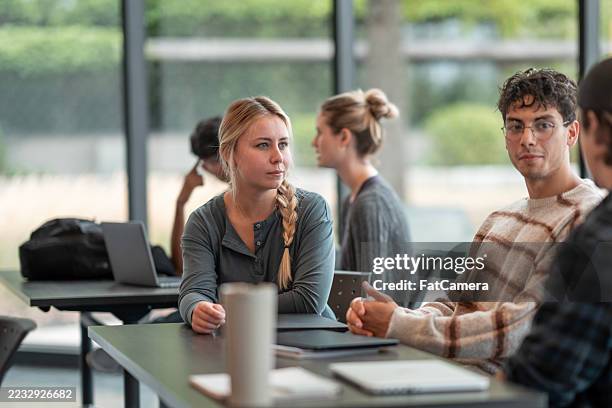 young adults collaborating in a modern college setting around a table - college admission stock pictures, royalty-free photos & images