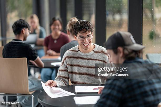diverse university students collaborating during a group project in bright modern space - worksheet stock pictures, royalty-free photos & images