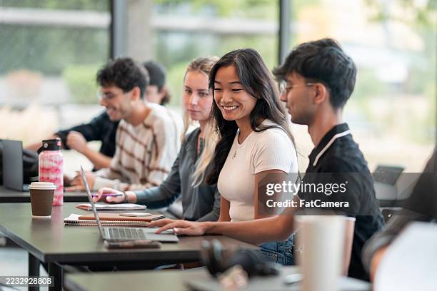 diverse students collaborating in modern classroom during interactive group session - college admission stock pictures, royalty-free photos & images