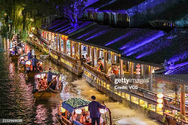 Tourists take a sightseeing boat on a river in the ancient town of Zhouzhuang at night on August 30, 2025 in Kunshan, Jiangsu Province of China.