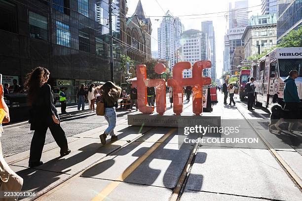 People walk around a giant TIFF sign during the Toronto International Film Festival in Toronto, Ontario, on September 4, 2025.