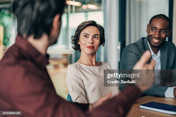 male leader talking to his team about plans on a meeting in the office - ceo stock pictures, royalty-free photos & images