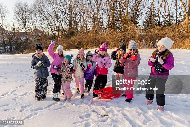 children throw snowballs under gray winter sky - ski-wear stock pictures, royalty-free photos & images