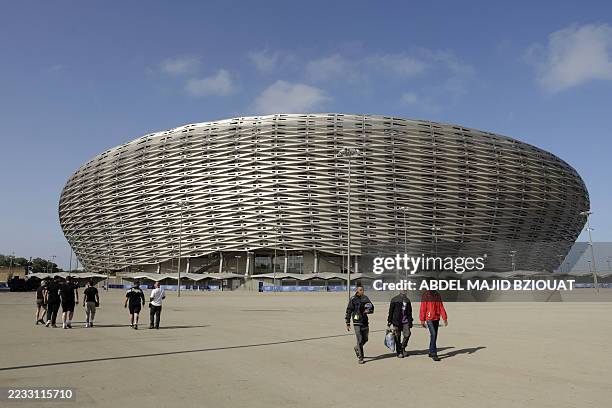 People walk near the new Prince Moulay Abdellah Stadium in Rabat, which was completely demolished in 2023 and rebuilt according to the latest...
