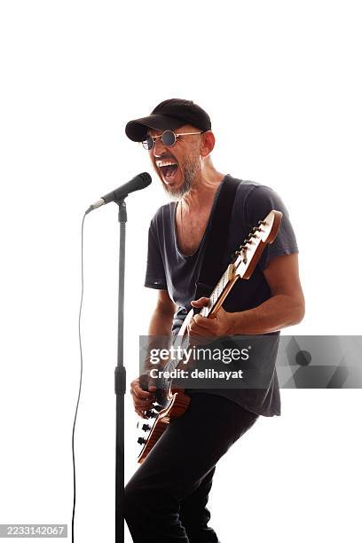músico de rock, cantando apasionadamente y tocando su guitarra eléctrica con energía desenfrenada - rock alternativo fotografías e imágenes de stock