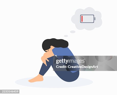 Müde Frau mit einem Symbol für schwache Batterie über dem Kopf, die auf dem Boden sitzt und ihre Knie umarmt. Depressionen, emotionales Burnout und psychische Probleme Müde Frau mit einem Symbol für schwache Batterie über dem Kopf, die auf dem Boden sitzt und ihre Knie umarmt. Depressionen, emotionales Burnout und psychische Probleme