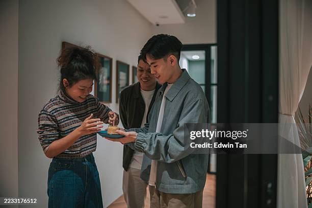 asian female hands lighting candle on small birthday cake during casual office celebration - birthday candle stock pictures, royalty-free photos & images