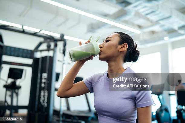 asian athlete drinking health shake after training session - proteína imagens e fotografias de stock