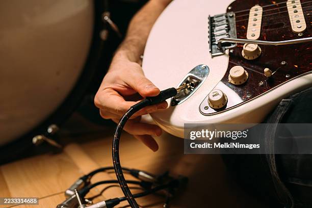 close-up of plugging cable into electric guitar - amplifier stock pictures, royalty-free photos & images