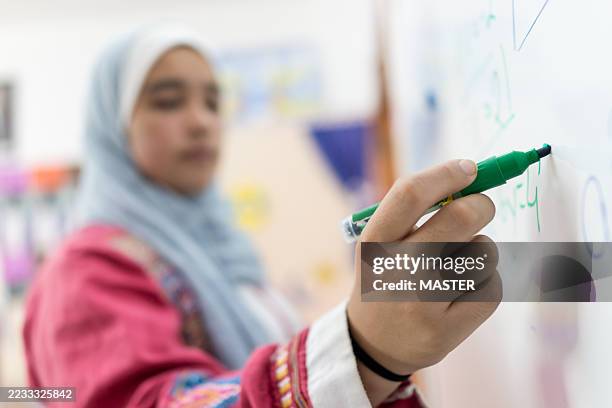 female teacher writing on whiteboard - religious veil stock pictures, royalty-free photos & images