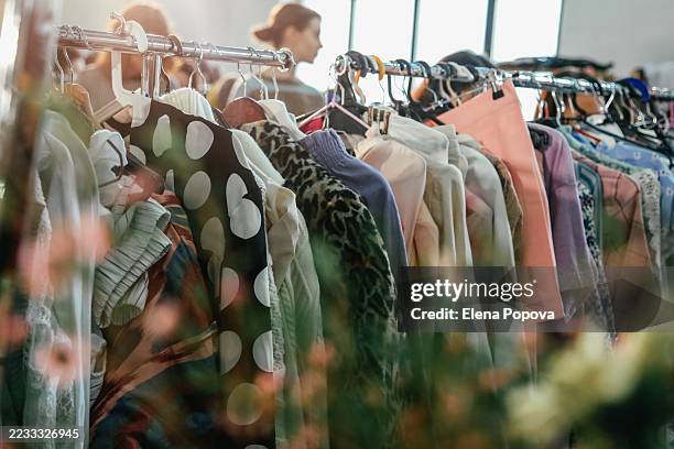 garage sale with thrifting and colorful dresses on cloth racks - second hand sale stock pictures, royalty-free photos & images