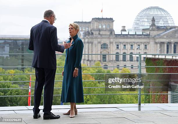 German Chancellor Friedrich Merz and Swiss President Karin Keller-Sutter speak with one another while standing on a terrace at the Chancellery as the...