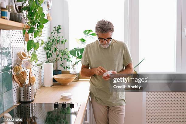 man checking smoke detector batteries at home - sensor stockfoto's en -beelden