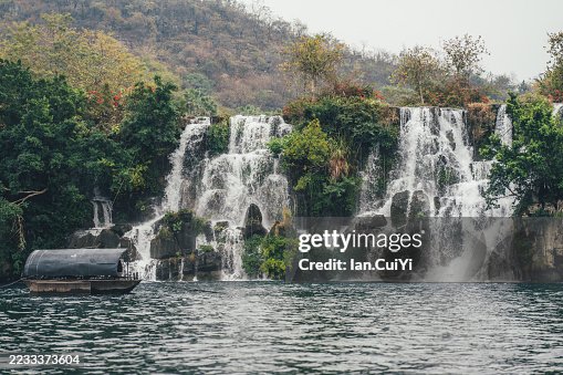 Scenic Multi-Tiered Waterfall with Covered Boat, Liuzhou, Guangxi, China Scenic Multi-Tiered Waterfall with Covered Boat, Liuzhou, Guangxi, China