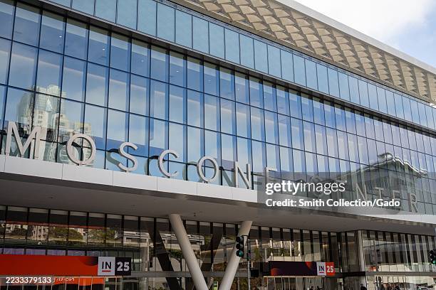 Glass facade of Moscone Center with large signage and reflections of downtown buildings, San Francisco, California, August 29, 2025.