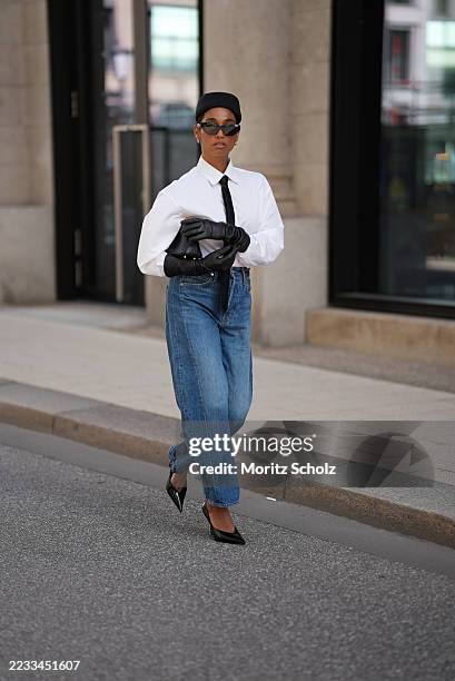 Cherifa Akili is seen wearing a long-sleeved white button-down blouse from Closed, tucked into the jeans; a slim black necktie from Drykorn;...