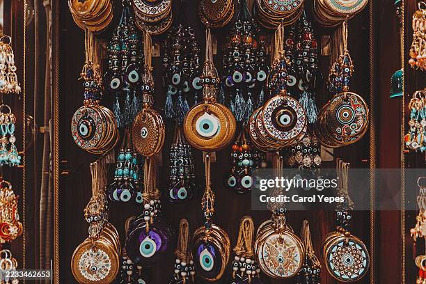 traditional turkish evil eye souvenirs, colorful glass charms displayed on a market stall - good luck charm stock pictures, royalty-free photos & images