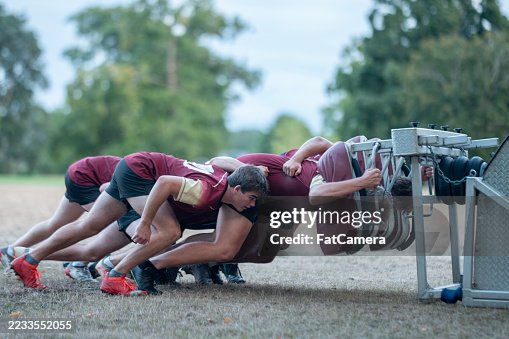 Rugby Players Training with Scrum Machine Outdoors on a Sunny Day Rugby Players Training with Scrum Machine Outdoors on a Sunny Day
