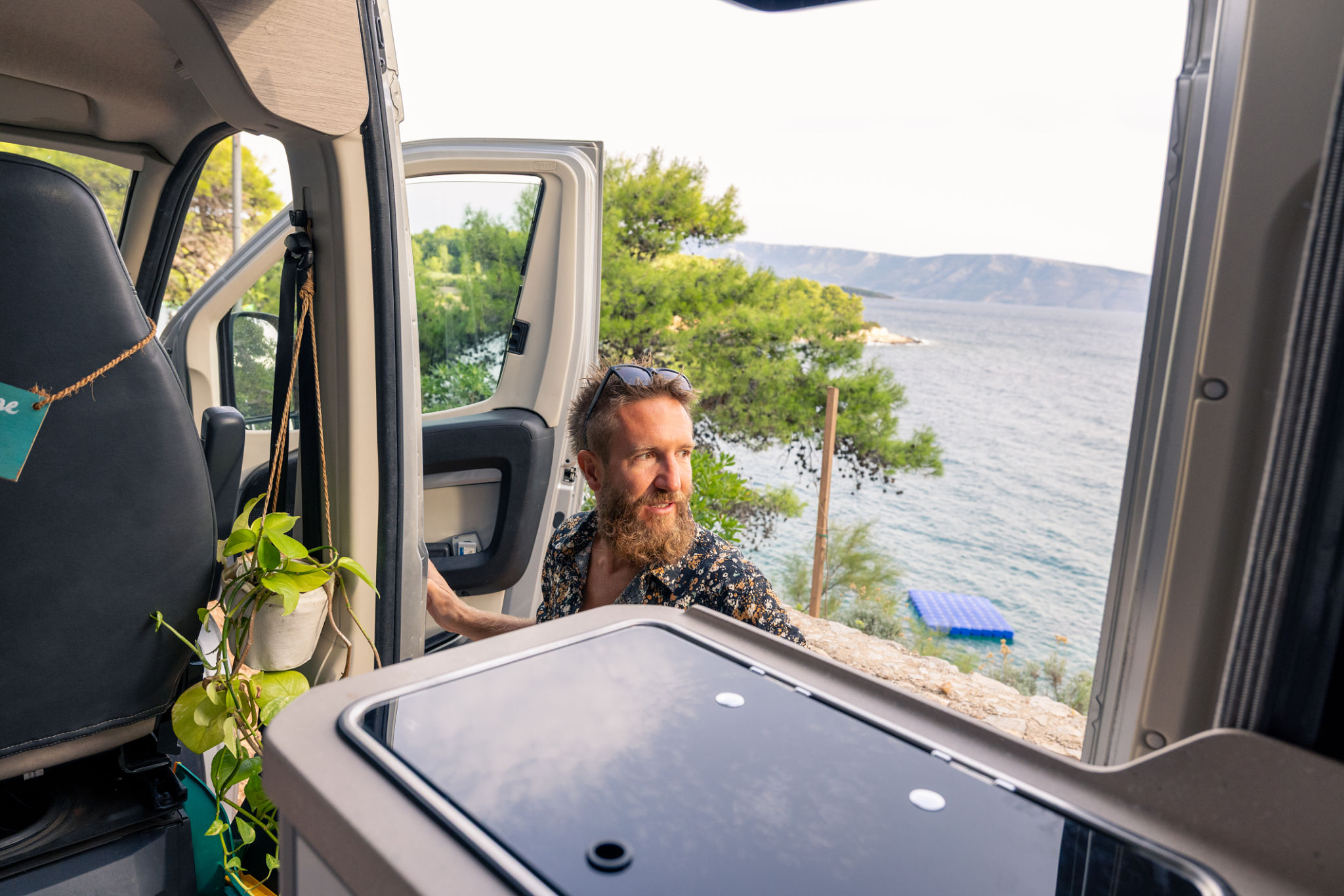 Man Enjoying Coastal View from Camper Van Door Man Enjoying Coastal View from Camper Van Door