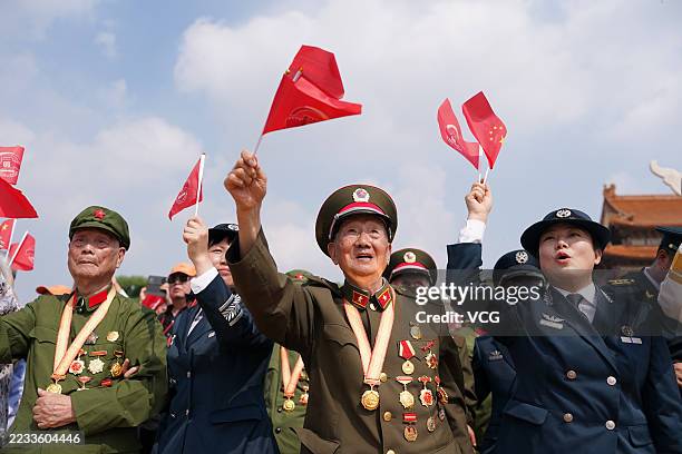 Veterans wave flags while watching V-Day military parade to commemorate the 80th anniversary of the victory in the Chinese People's War of Resistance...