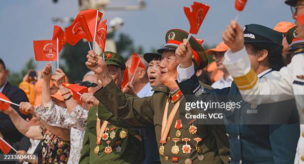 Veterans wave flags while watching V-Day military parade to commemorate the 80th anniversary of the victory in the Chinese People's War of Resistance...