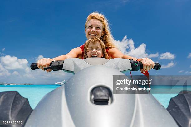 happy single mother and son having fun on jet boat at sea. - jet boating stock pictures, royalty-free photos & images
