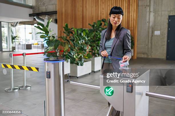 businesswoman using access card to enter modern office building - entrance gate stock pictures, royalty-free photos & images