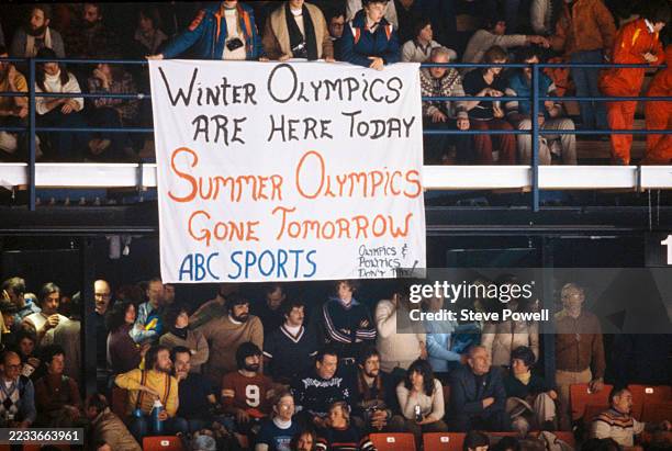 Spectators in the stands unfurl a banner in reference to a boycott of the 1980 Moscow Olympic Summer Games following the Soviet Union invasion of...