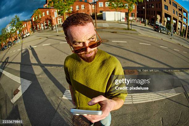 young man adjusting sunglasses and smiling while commuting in the city - fish eye lens stock pictures, royalty-free photos & images