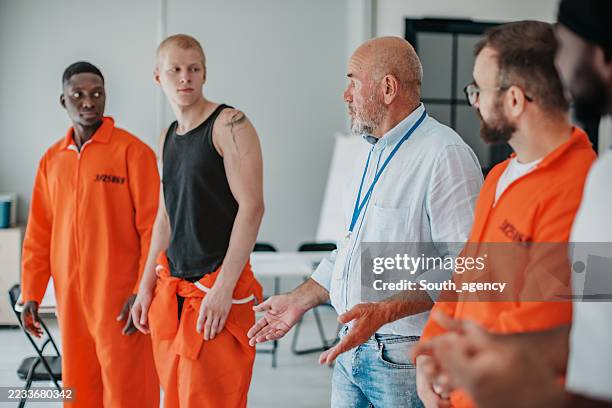 prisoner education program fosters teamwork and hope among diverse participants in a modern classroom setting - prisoner stock pictures, royalty-free photos & images
