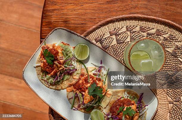 mexican prawn seafood tacos served with margarita cocktail drink, lime, avocado guacamole, cilantro and salad in sunny tulum restaurant - food styling stock pictures, royalty-free photos & images