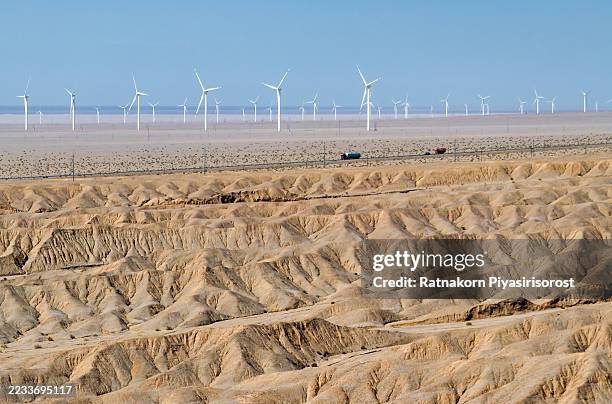 wind turbines rise from eroded desert in gansu, china, harnessing renewable energy. - provinz gansu stock-fotos und bilder