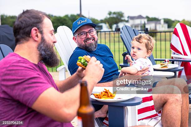 brothers enjoying burgers and beer on 4th of july - texas bbq stock pictures, royalty-free photos & images