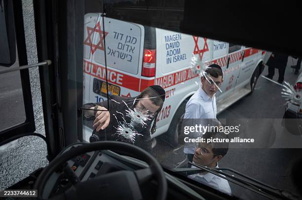 September 2025, Israel, Jerusalem: Israelis look at gunshots on the wind-shield of a bus after a shooting attack at a bus stop in Jerusalem. The...