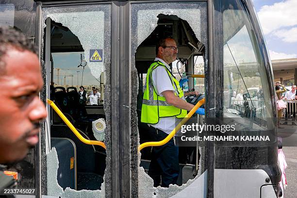 Member of Israel's ZAKA search and rescue emergency services stands inside a damaged bus at the scene of a shooting at the Ramot road junction in...