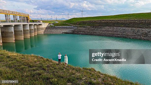 aerial view of couple above reservoir below hydro dam - hydroelectric power station stock pictures, royalty-free photos & images