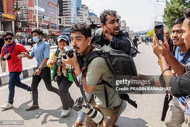 Photojournalist carries an injured fellow journalist during a protest outside the Parliament building in Kathmandu on September 8 against social...