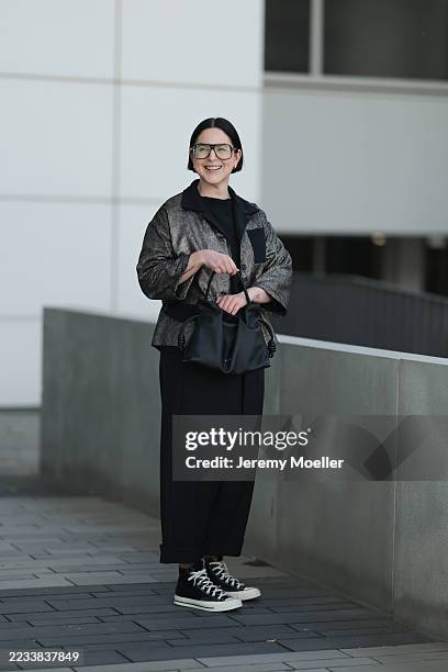 Maria Barteczko seen wearing Victoria Beckham oversized square aviator-style glasses with a black frame, WENDYKEI black blouse with ruched collar,...