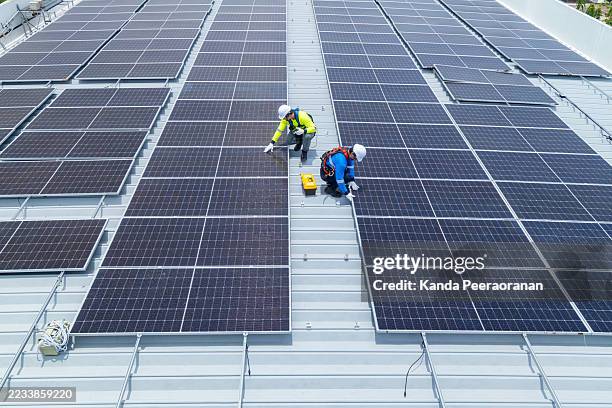 technicians maintaining rooftop solar panel system - prison cell stock pictures, royalty-free photos & images
