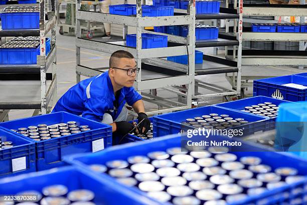 Workers produce new energy vehicle batteries on the production line of Huating New Energy Technology Co., Ltd. In Liuzhou, Guangxi, China, on...