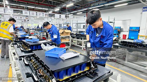 Workers produce new energy vehicle batteries on the production line of Huating New Energy Technology Co., Ltd. In Liuzhou, Guangxi, China, on...