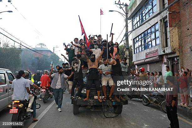 Protesters carry Nepal's national flag as they ride a police truck outside the President House in Kathmandu on September 9 a day after a police...