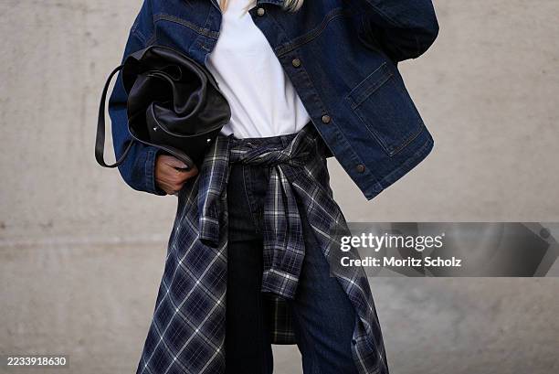 Mirja Klein is seen wearing a classic white crew-neck T-shirt from COS; a dark blue oversized MalleMW Casual denim jacket with button closure, shirt...