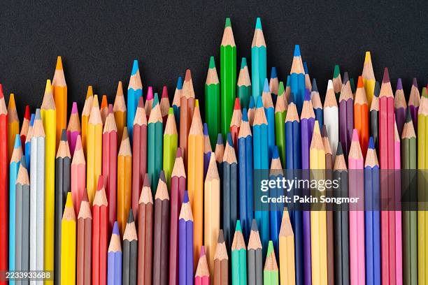 sharpened colored pencils on black leather background. - colored pencil stock pictures, royalty-free photos & images