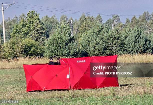 Investigators inspect a site where it is believed that parts of a drone fell, probably after it was shot down, in Czosnowka near Biala Podlaska,...