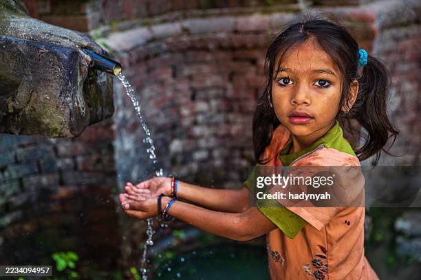 young nepali girl drinking from city fountain on durbar square - nepal children stock pictures, royalty-free photos & images