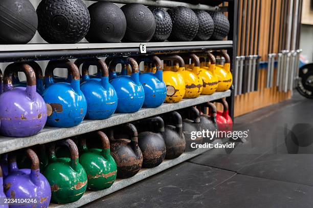 rack of kettlebells and medicine balls in a gym - dumbbell stock pictures, royalty-free photos & images