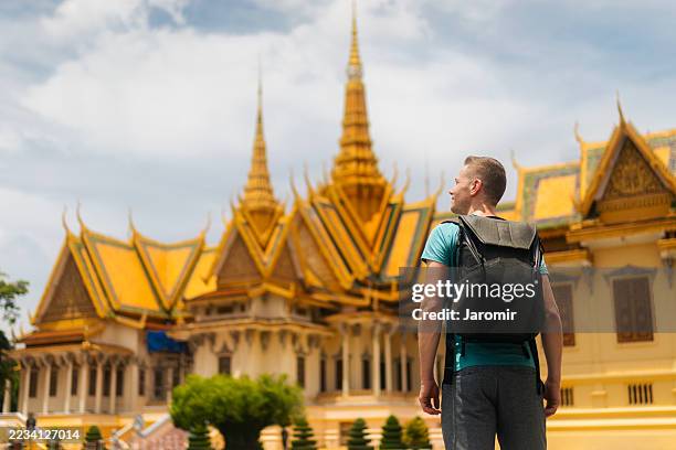 tourist with backpack against royal palace in cambodia - cambodia stock pictures, royalty-free photos & images