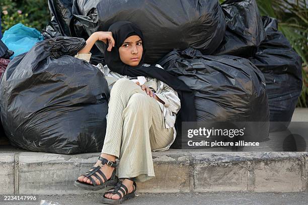 September 2025, Lebanon, Beirut: Syrian refugee Hasna, sits next to her belongings as she waits with her family to leave Beirut. Three hundred Syrian...